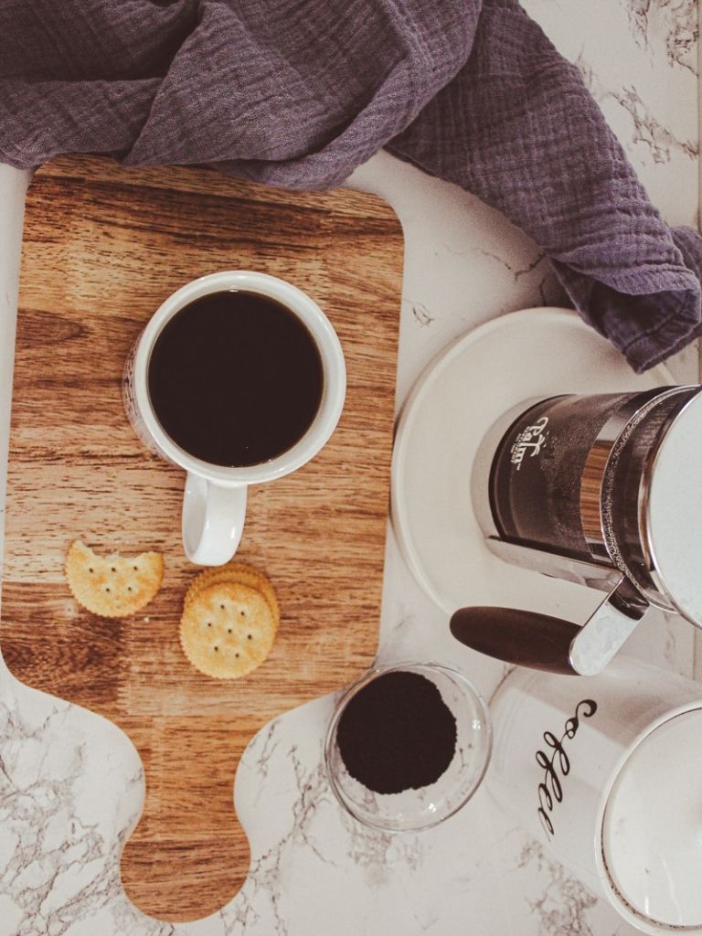 French Press Coffee in a cup and coffee grounds